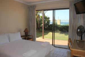 um quarto com uma cama e uma porta de vidro deslizante em Glenashley Beach Accommodation - B&B and Backpackers em Durban