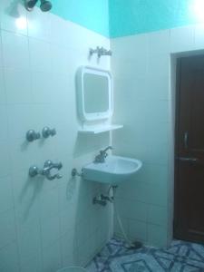 ブッダガヤにあるAnsari Houseのバスルーム(洗面台付)、壁掛けテレビが備わります。