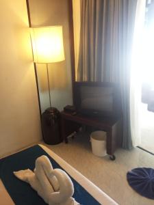 a room with a room with a television and a towelanimal at Bliss Resort Krabi in Klong Muang Beach