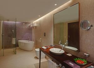 a bathroom with a large mirror and a tub and a sink at The Park Visakhapatnam in Visakhapatnam