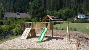 un parque infantil de madera con un tobogán en un patio en Hotel Panorama, en Elbigenalp