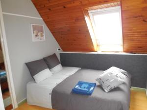 Un dormitorio con una cama con un libro azul. en Chambre d'hôtes proche de Brest et Landerneau, en Dirinon