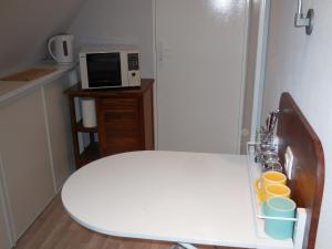 cocina con mesa blanca y microondas en Chambre d'hôtes proche de Brest et Landerneau, en Dirinon