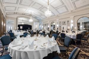 a banquet hall with tables and chairs and chandeliers at Castle Hotel Windsor in Windsor