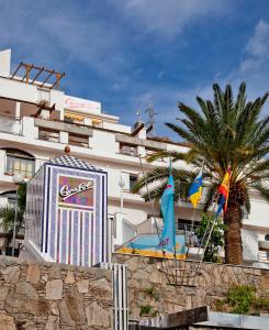 a large building with flags in front of it at Cura Sol in Playa del Cura