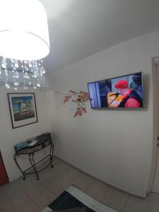 a living room with a tv on the wall at Eden's Sweet Place in Eilat