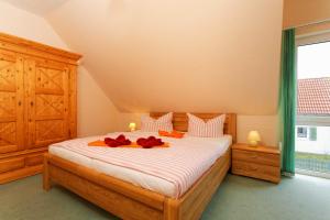 a bedroom with a bed with red flowers on it at Weidenweg 06 in Ostseebad Karlshagen