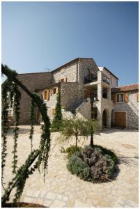 a large stone building with a tree in front of it at Apartments Villa Stapo in Umag