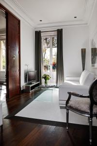a white room with a bed and a television at Hospes Puerta de Alcalá, a Member of Design Hotels in Madrid