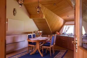 a kitchen with a wooden table and blue chairs at Apartment Velbana Gorca in Virštanj