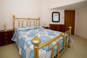 1 dormitorio con 1 cama con edredón azul y blanco en Casa Nonna Elvira en Roccalumera
