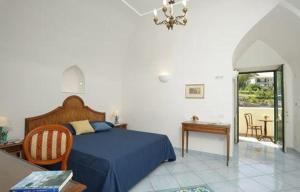 a bedroom with a blue bed and a table at Il Ducato Di Ravello in Ravello