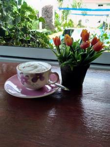 een kopje koffie en een vaas met bloemen op een tafel bij Peace Pool Resort in Khun Han