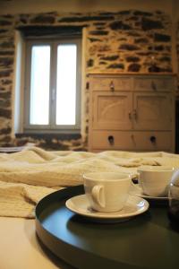 a tray with two coffee cups on a bed at Alitanes in Áno Meriá