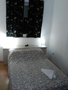 - une chambre avec un lit et une couverture noire et blanche dans l'établissement Keti 2, à Belgrade