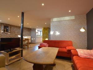 - un salon avec un canapé, une télévision et une table dans l'établissement Gorgeous Holiday Home in Ovifat with Sauna, à Waimes
