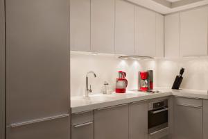 a kitchen with white cabinets and red appliances at The Grand Tarabya Hotel in Istanbul