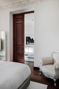 a bedroom with a bed and a couch at Hospes Puerta de Alcalá, a Member of Design Hotels in Madrid