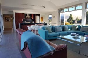 a living room with blue couches and a kitchen at Tekapo Retreat in Lake Tekapo
