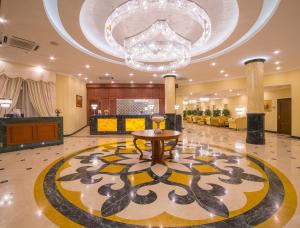 a lobby with a table and a chandelier at Ramada by Wyndham Almaty in Almaty