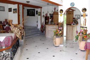 dos imágenes de una habitación con flores en jarrones en Rosmari Hotel en Archangelos