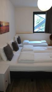 ein großes Bett mit weißer Bettwäsche und Kissen darauf in der Unterkunft Hotel Ladeuze in Löwen