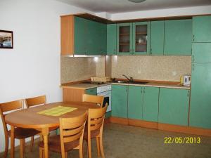 kuchnia z zielonymi szafkami i drewnianym stołem w obiekcie Apartment in Kambani 1 Apartcomplex w Swetim Własie