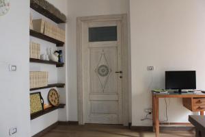 een deur in een kamer met een bureau en een televisie bij La Corte di Grazia_IUN P2039/40 in Nuoro