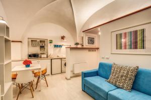ローマにあるCoronari stylish apartmentのリビングルーム(青いソファ、テーブル付)