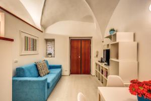 a living room with a blue couch and a wooden door at Coronari stylish apartment in Rome