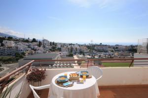 a table with food on top of a balcony at Panorama de Nerja in Nerja