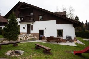 a house with a picnic table and benches in front of it at Vila Sekvoj in Harrachov