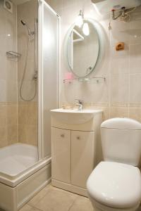 a bathroom with a toilet and a sink and a shower at Paradise Hotel in Gomel