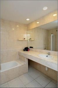 ein Badezimmer mit einem Waschbecken, einer Badewanne und einem Spiegel in der Unterkunft Apartament IMA in Lloret de Mar