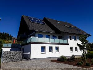 een huis met zonnepanelen op het dak bij Apartment Schanzenstraße 690 m ü. M in Winterberg