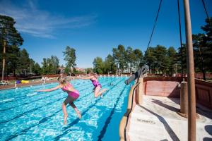 dos jovencitas saltando a una piscina en First Camp Orsa - Dalarna en Orsa