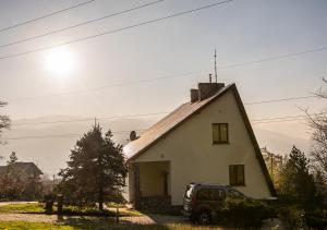 ビェルスコ・ビャワにあるCezar Naturyzm Bielsko-Białaの小さな白い家の隣に停められた車