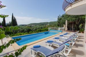 a swimming pool with chaise lounge chairs next to a swimming pool at Villa Ana Maria in Zaton