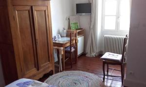 Cette chambre comprend un bureau et une table avec une chaise. dans l'établissement Chambre d'Hôtes La Tour de Brazalem, à Nérac