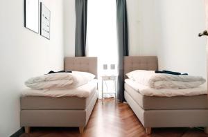zwei Betten nebeneinander in einem Zimmer in der Unterkunft KATZ by ROCKCHAIR Apartments l SUPERHOST Status l 3 Bedrooms Boxspringbeds 2 Bathrooms in City Center - Cozy Family & Business Flair welcomes you! in Berlin + 6 Fotos