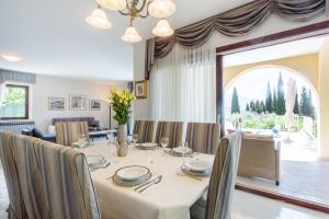 une salle à manger avec une table, des chaises et une grande fenêtre dans l'établissement Villa Ana Maria, à Zaton