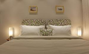 a bedroom with a large white bed with two lamps at Bungalow 99 in New Delhi