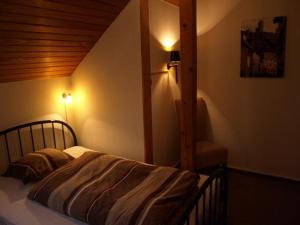a bedroom with a bed with a wooden ceiling at Bed&Breakfast Eifelpension Brückenschenke in Fuchshofen
