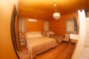a bedroom with two beds and a tv in a room at Café e Cabanas Lenha no Fogo in Urubici