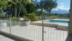 une clôture en face d'une piscine dans l'établissement Sitio cachoeira de macacu, à Guapimirim