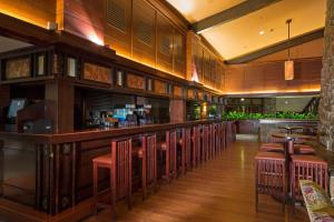 um restaurante com um bar com bancos vermelhos em Disney Sequoia Lodge em Coupvray