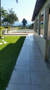 a walkway in front of a building with a lawn at Sitio cachoeira de macacu in Guapimirim