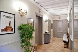 a hallway with a chandelier and a plant at La Croce d'Oro Santa Croce Suite Apartments in Florence +100 photos