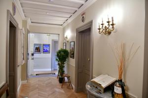 a hallway with a chandelier and a table in a room at La Croce d'Oro Santa Croce Suite Apartments in Florence