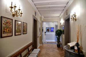 a hallway with a chandelier and paintings on the walls at La Croce d'Oro Santa Croce Suite Apartments in Florence